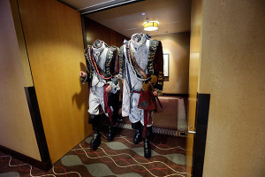 Two men dressed as headless characters get out of a hotel lift